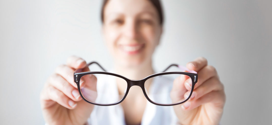 woman holding prescription eyeglasses