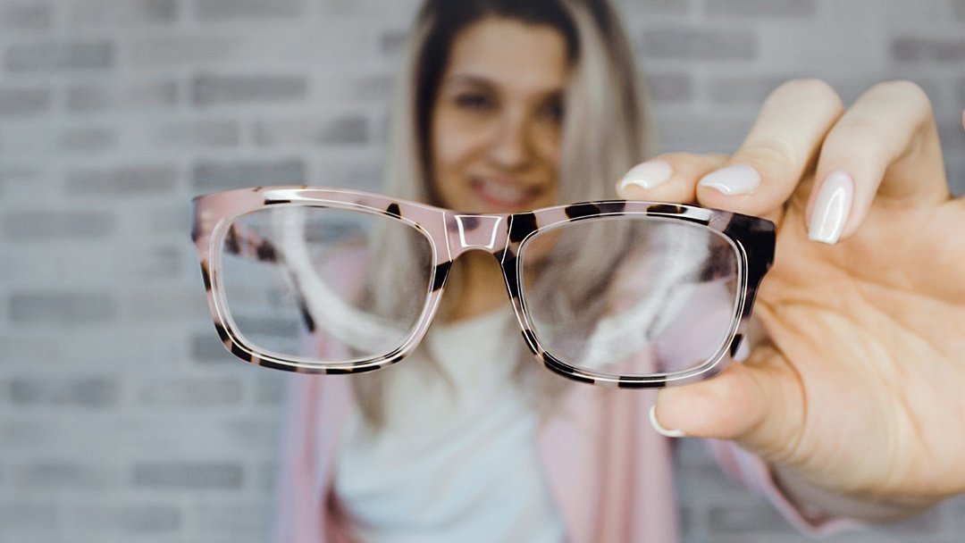 woman holding eyeglasses