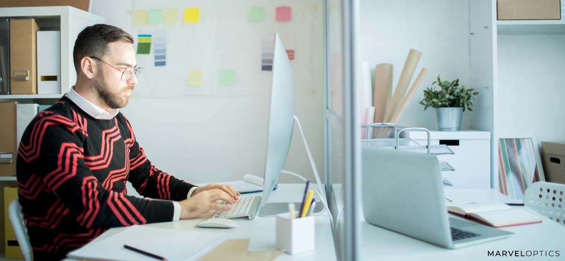 Man wearing prescription glasses in front of computer