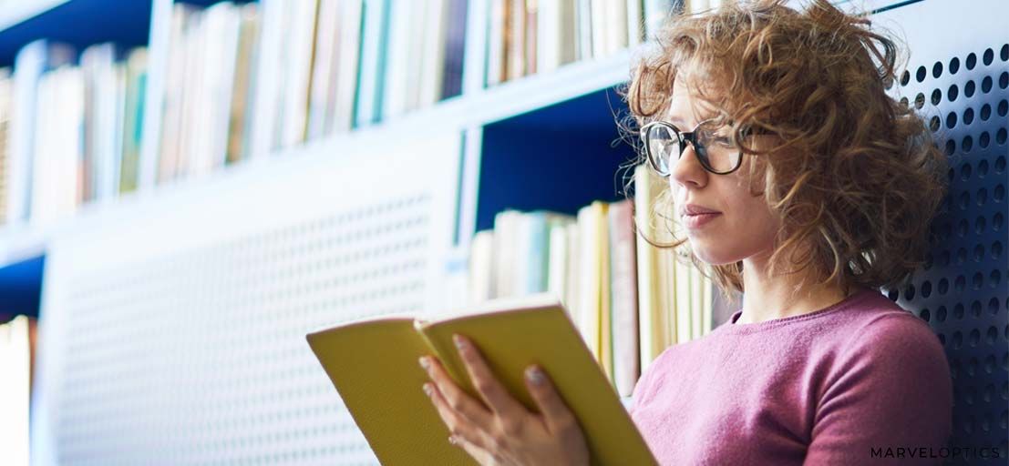 woman wearing prescription glasses while reading